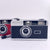 Retro 35mm film cameras in black and red with built-in flash and fixed 28mm lens.