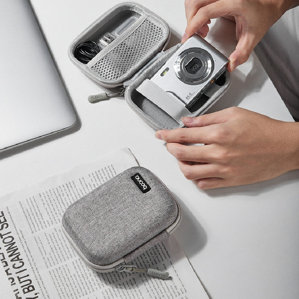 Mini camera bag in use, showcasing a gray protective case with a camera on a desk.