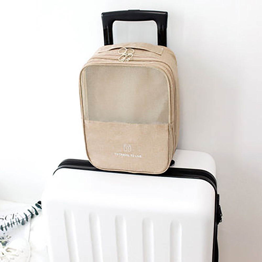 Portable waterproof shoe bag in khaki color on top of a white suitcase, ideal for travel organization.