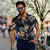 Casual vintage letter print short sleeve shirt for men, styled with sunglasses in a lively outdoor setting.