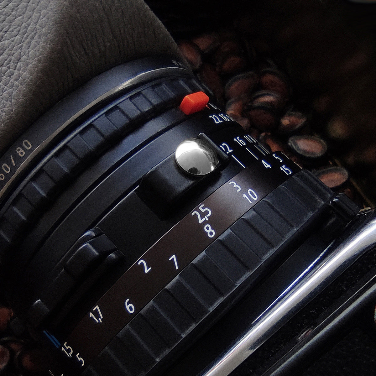 Close-up of a film camera lens with focus and aperture controls, showcasing detailed mechanics and design.