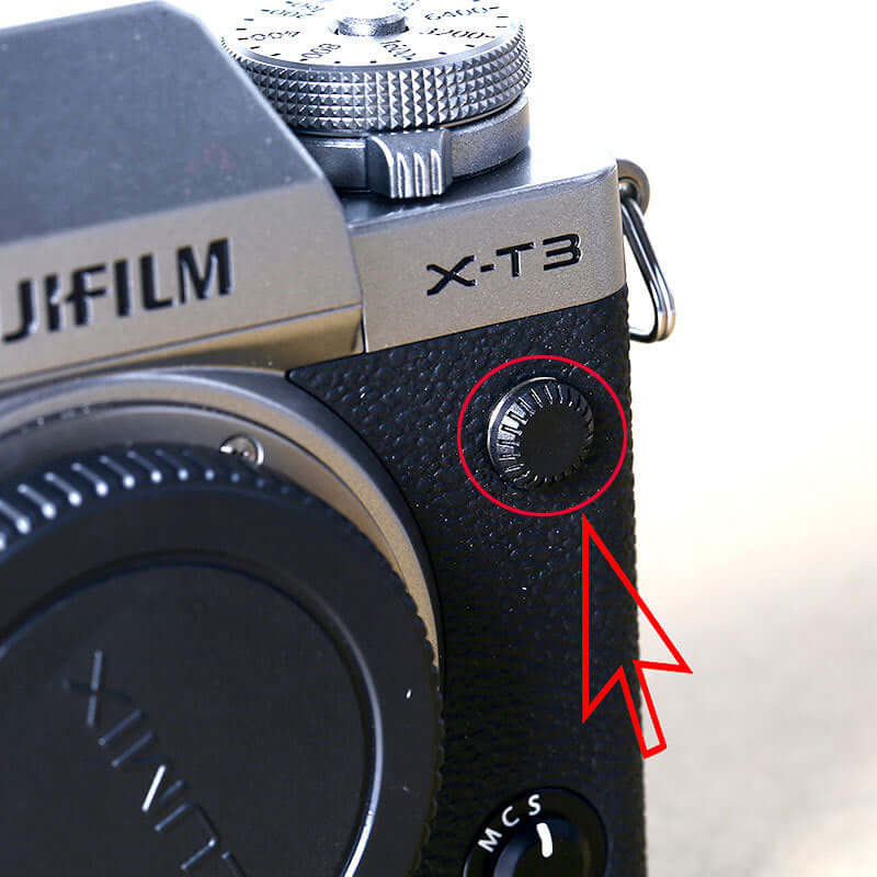 Close-up of a mechanical shutter button on a Fujifilm X-T3 camera, highlighting its black plastic design.