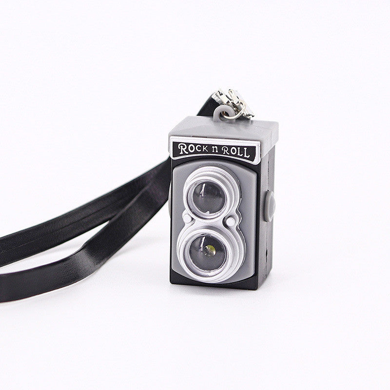 Shrinking toy accessories strap camera in gray with 'Rock n Roll' label, perfect for doll fashion play.