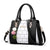 Stylish black and white shoulder bag for women with pom pom embellishments, perfect for everyday use.